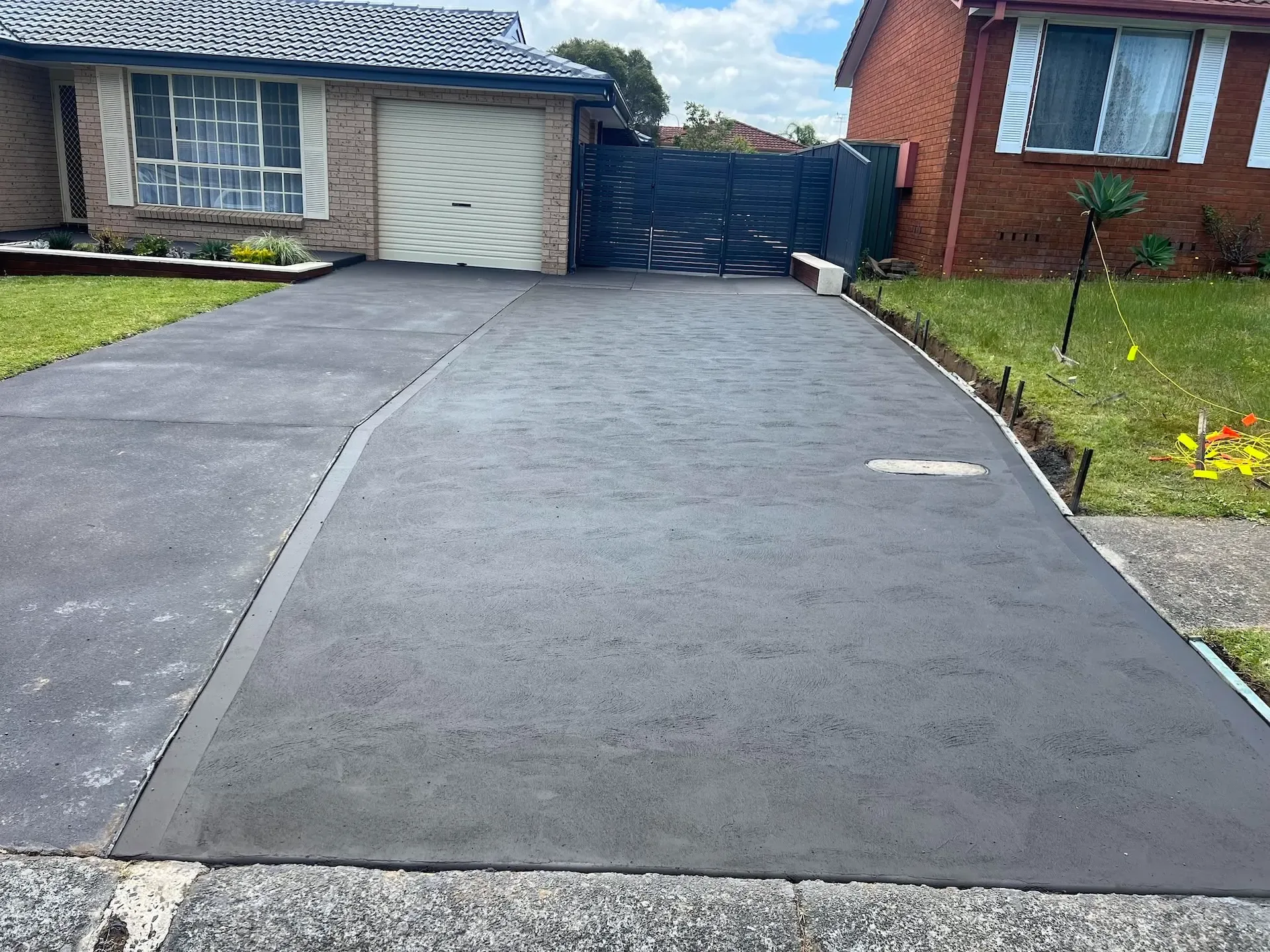 Finished concrete driveway leading to a residential garage