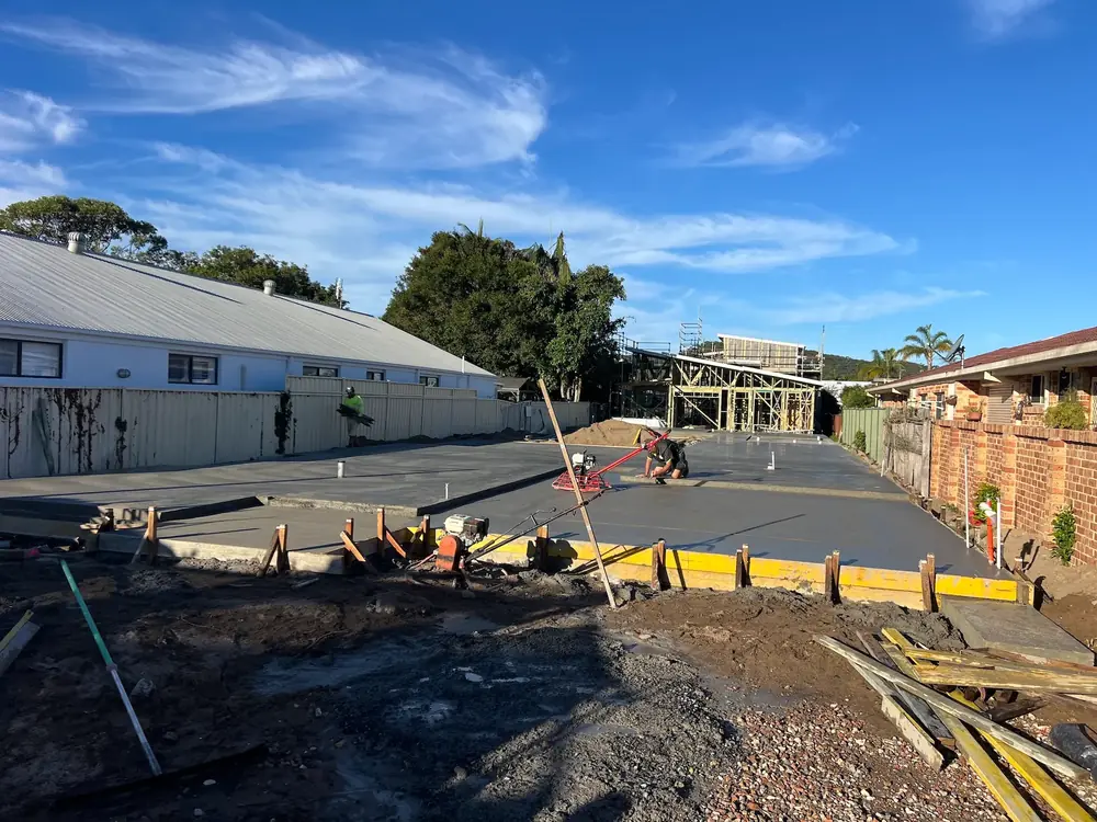 Fresh concrete pavement being finished in a residential development